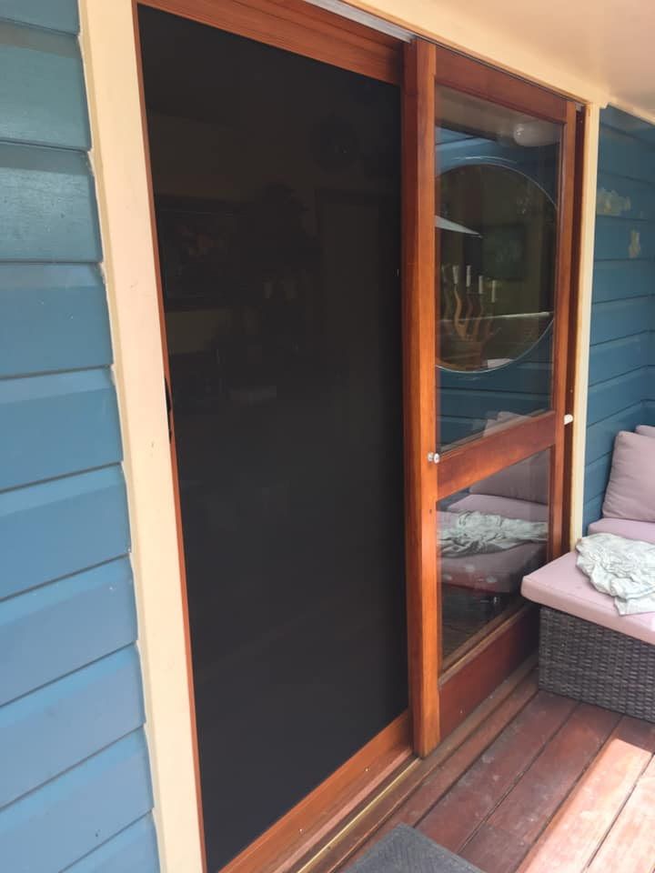 A Large Screen Is Hanging On A Wall Next To A Window — Screen Factory In Billinudgel, NSW