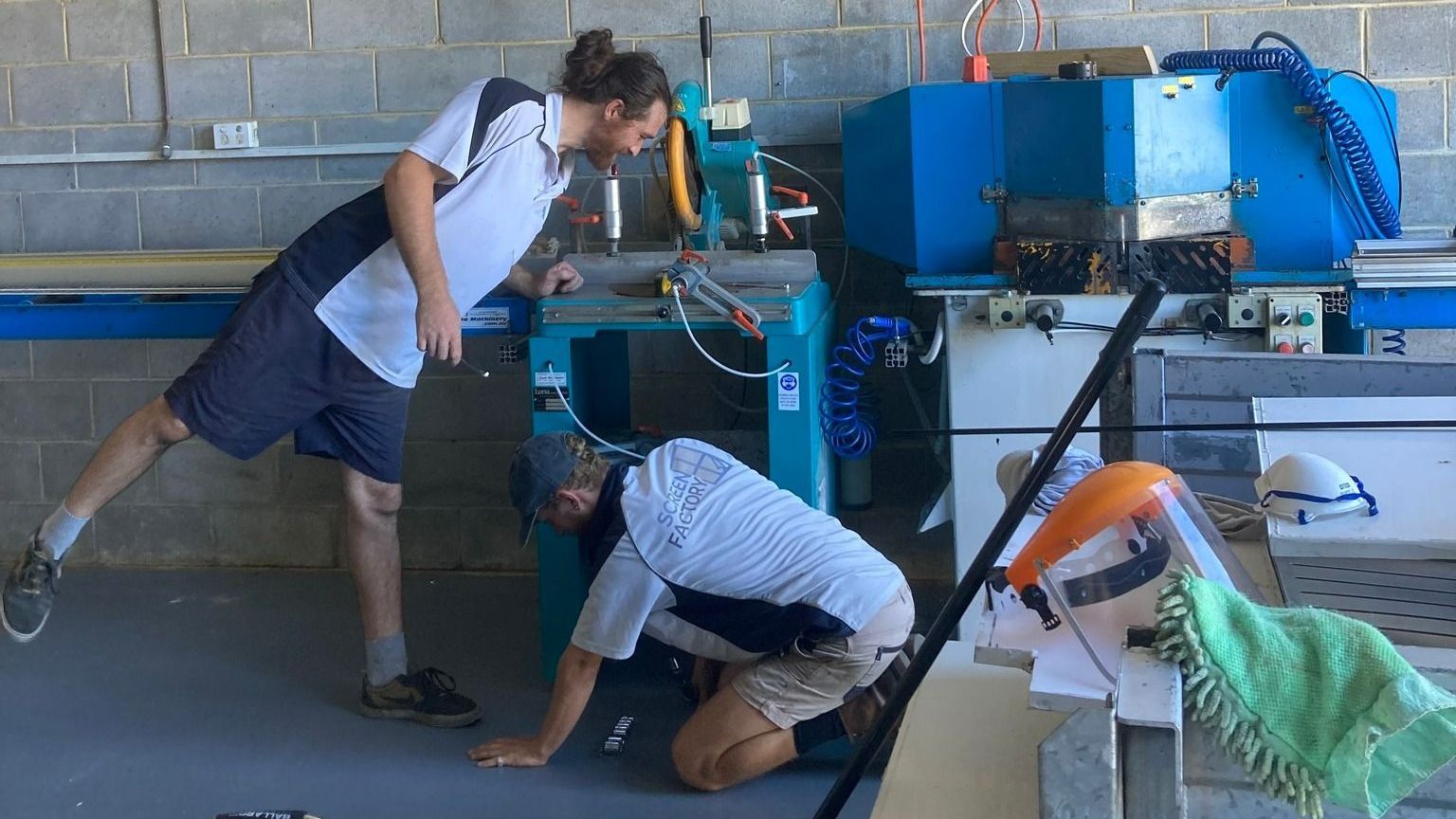 Two Men Are Working On A Machine In A Factory — Screen Factory In Billinudgel, NSW