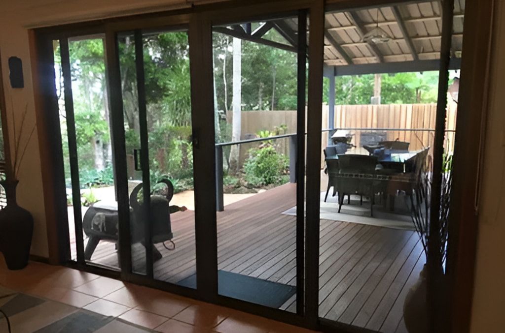A White Door With A Black Screen Is Open To A Brick Wall  — Screen Factory In Billinudgel, NSW