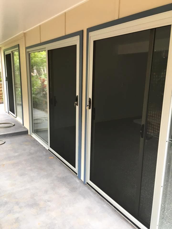 A Row Of Sliding Glass Doors With Black Screens — Screen Factory In Ocean Shores, NSW