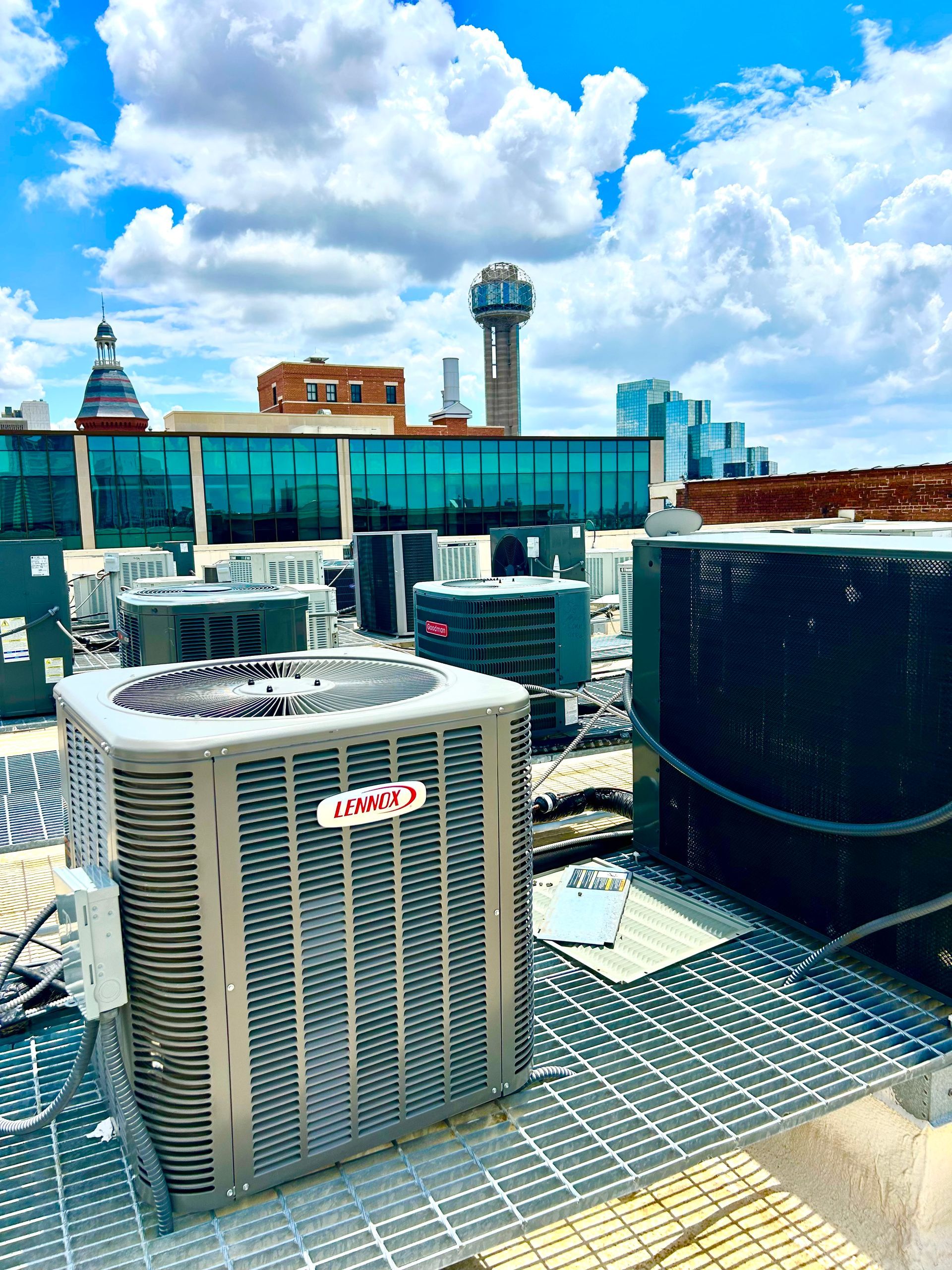 A row of air conditioners are sitting on top of a roof.