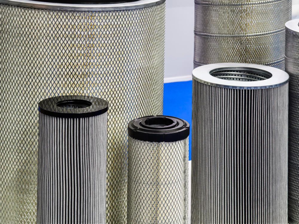Close-up of several cylindrical air filters with pleated paper and metal mesh.