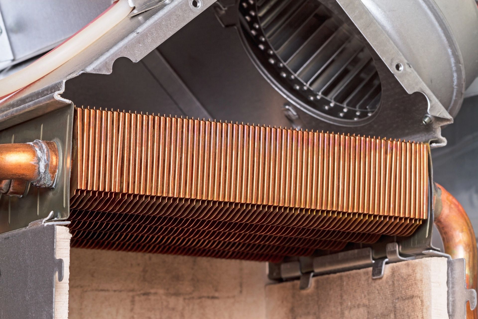 Cutaway view of a copper heat exchanger with multiple tubes, inside a furnace.