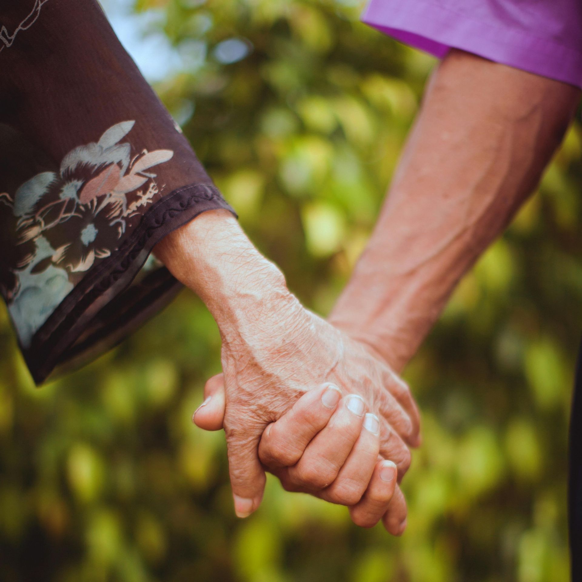 A man in a purple shirt is holding a woman 's hand