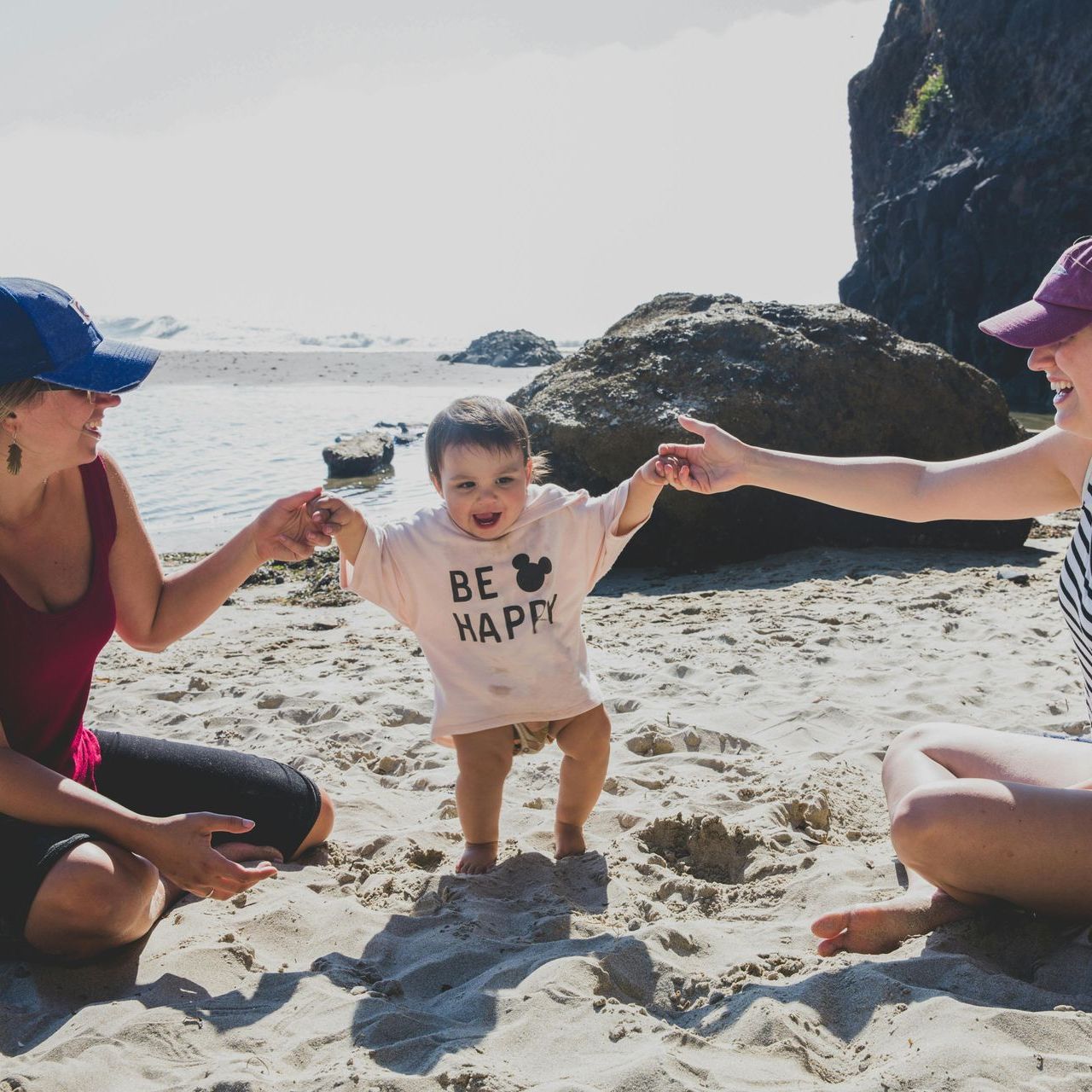A baby is wearing a shirt that says be happy