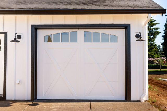 A white garage door is open in front of a house