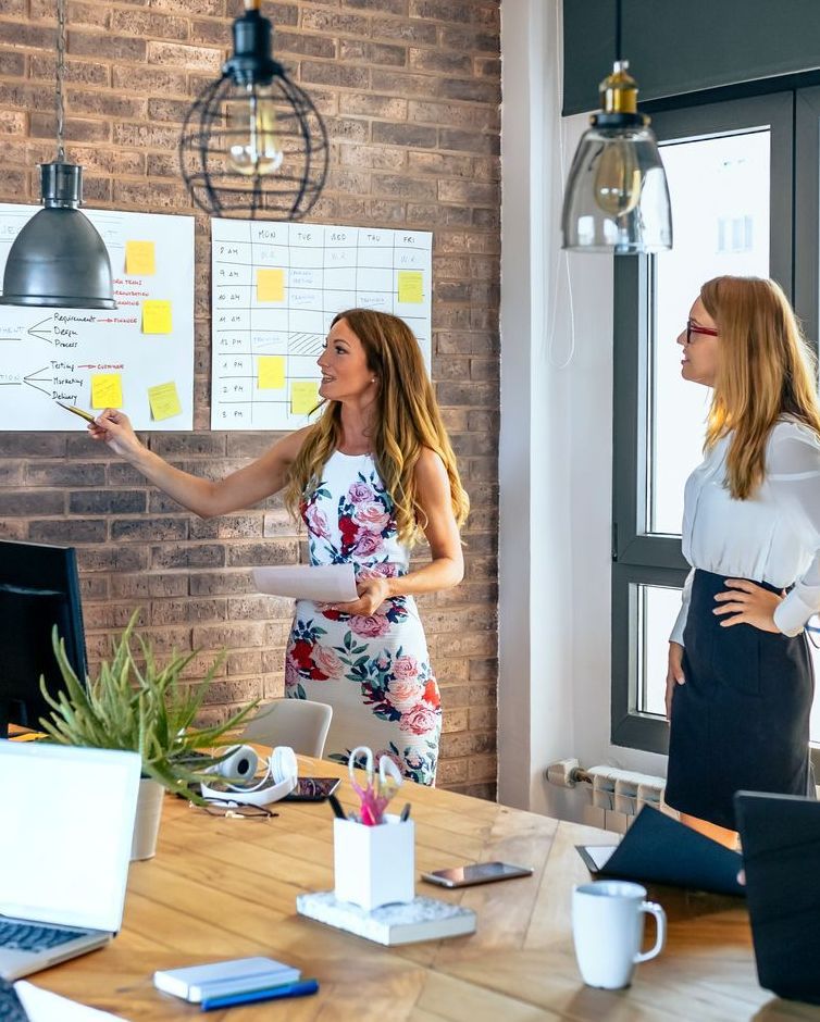 A woman is giving a presentation to a group of people in an office.