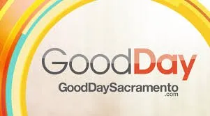 The logo for good day sacramento is a circle with a rainbow in the background.