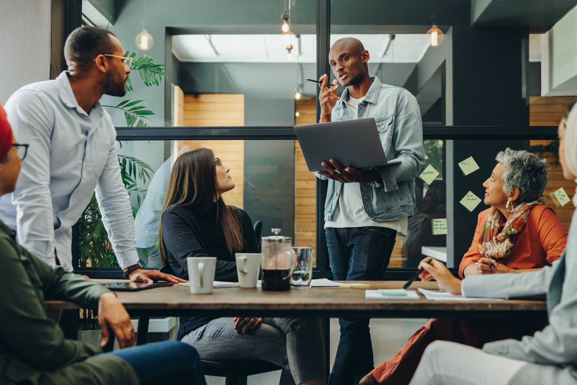 A group of people are sitting around a table having a meeting.