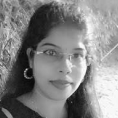 A woman with long hair is smiling in a black and white photo.
