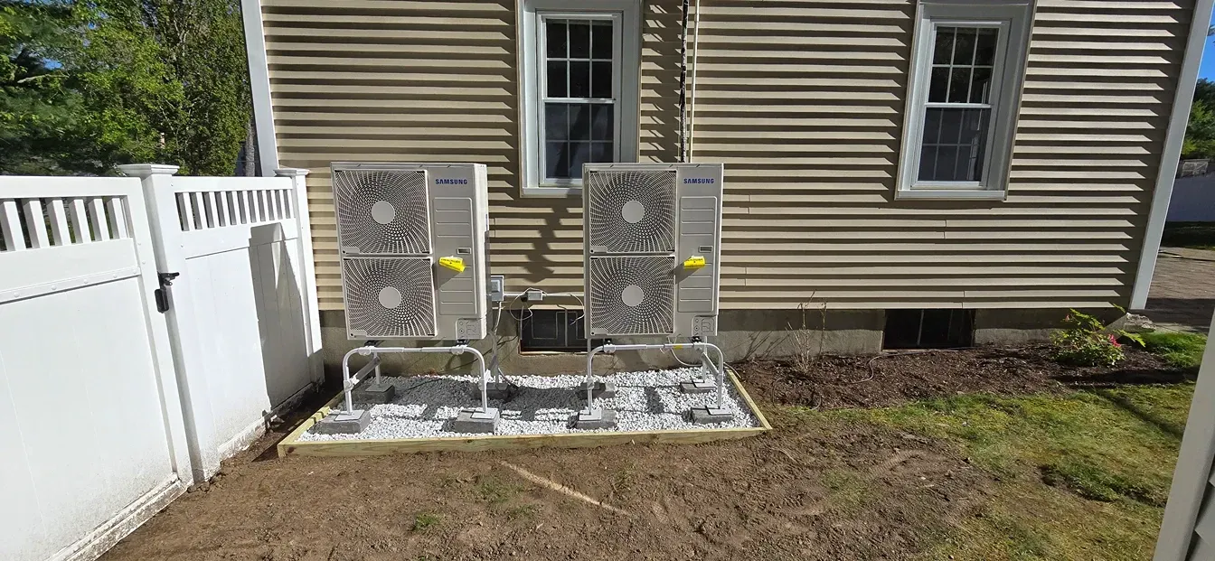 A house with two air conditioners on the side of it.