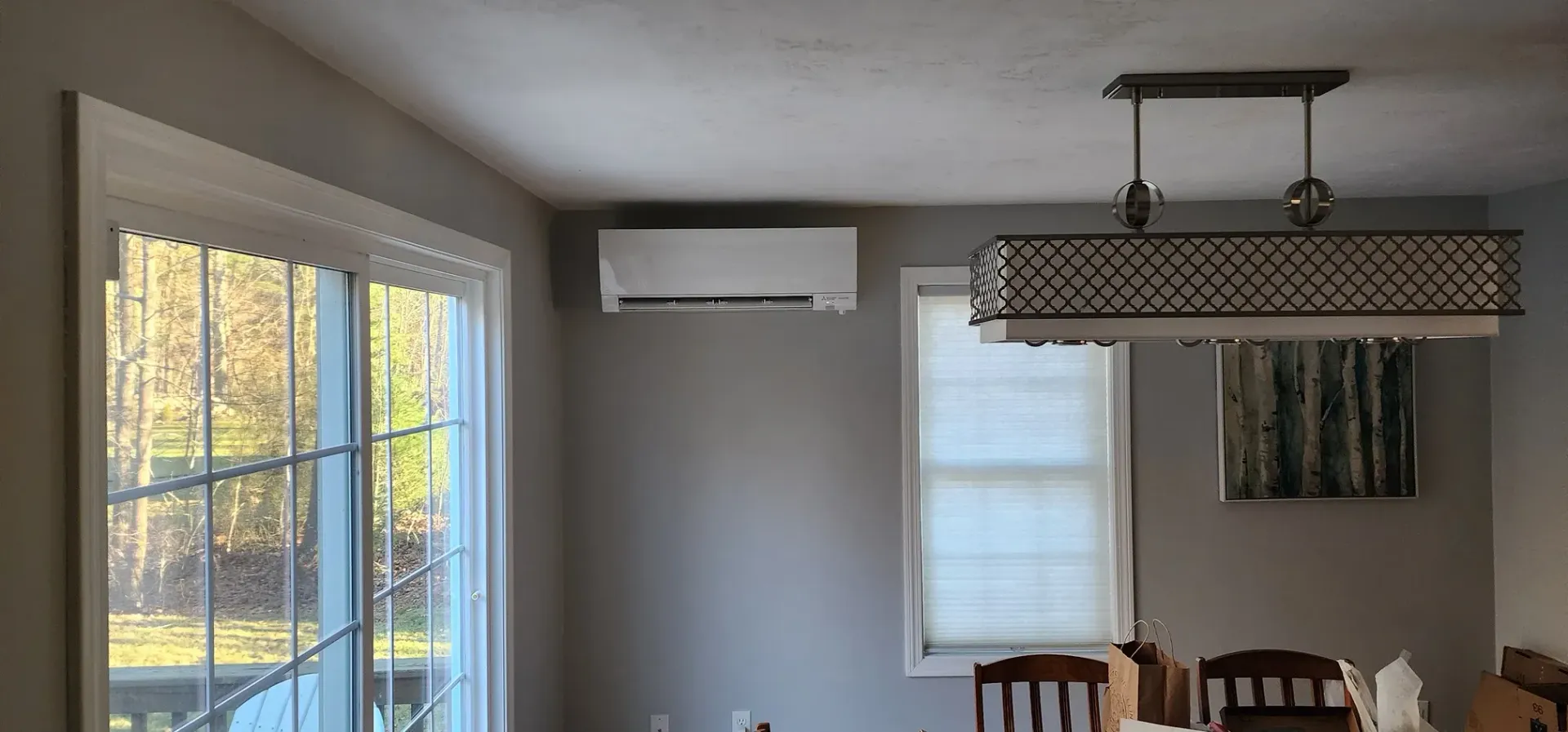A dining room with a table and chairs and a window.