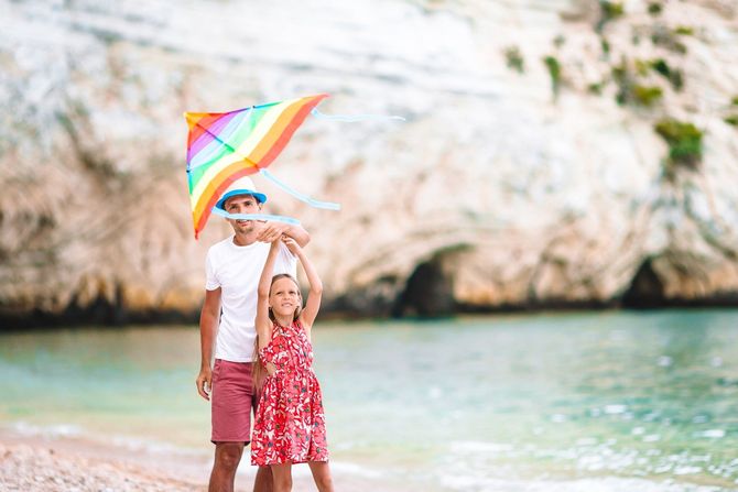 Vater und Tochter halten Laterne am Strand