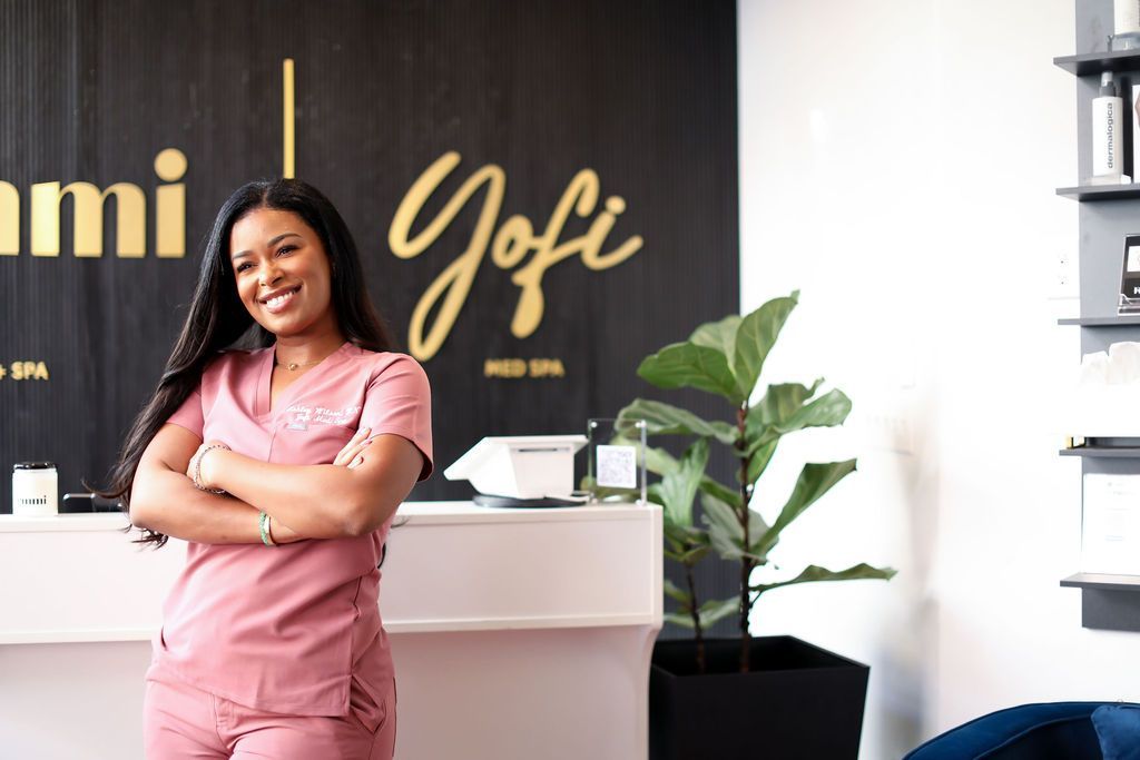 A woman in scrubs is standing in front of a counter in a spa.