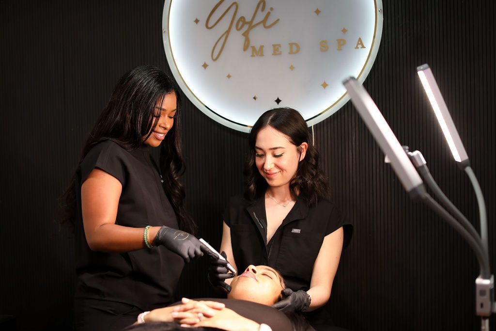 Two women are working on a woman 's face in a spa.