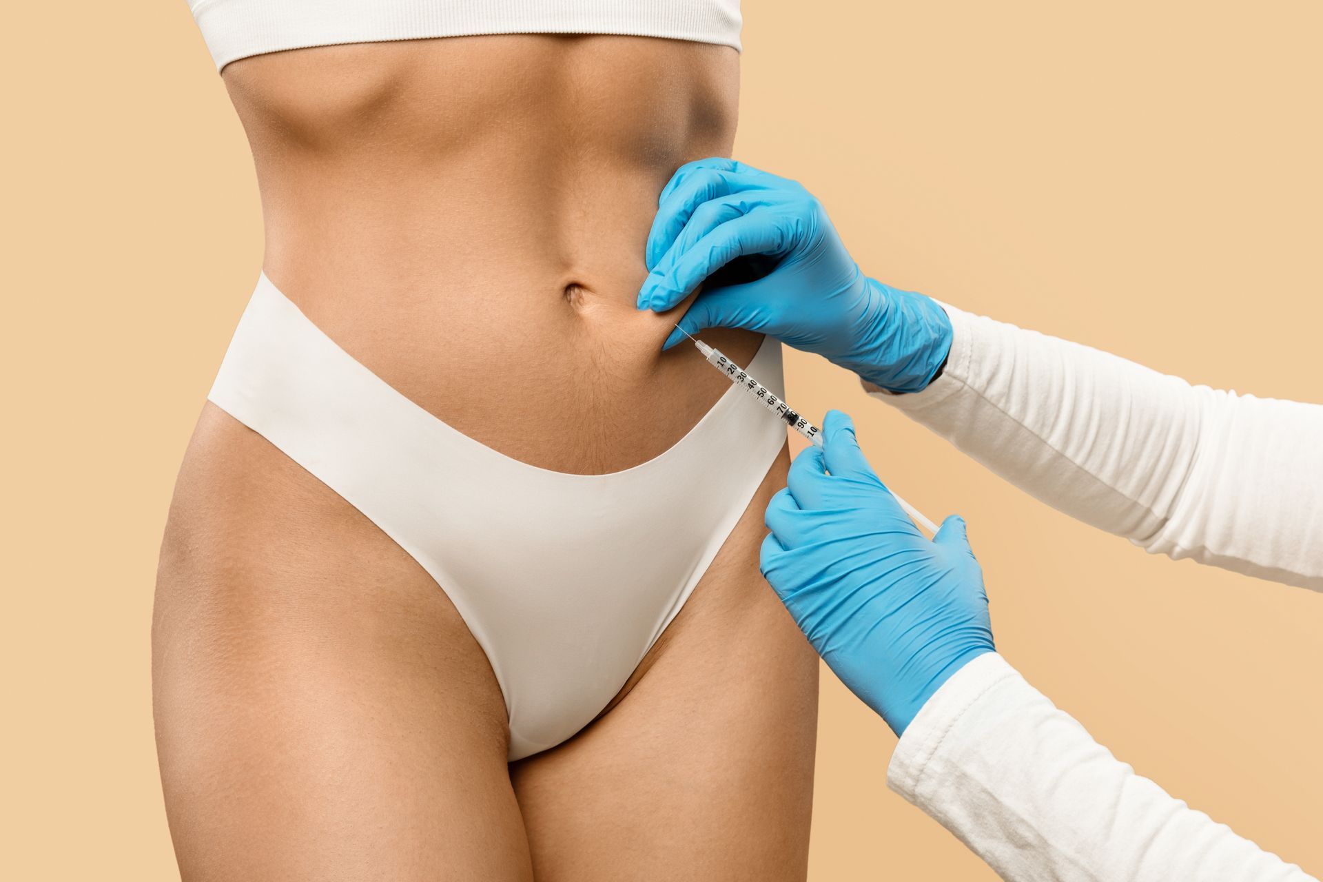 Healthcare worker preparing a patient for abdominal injection, with gloved hands and white underwear