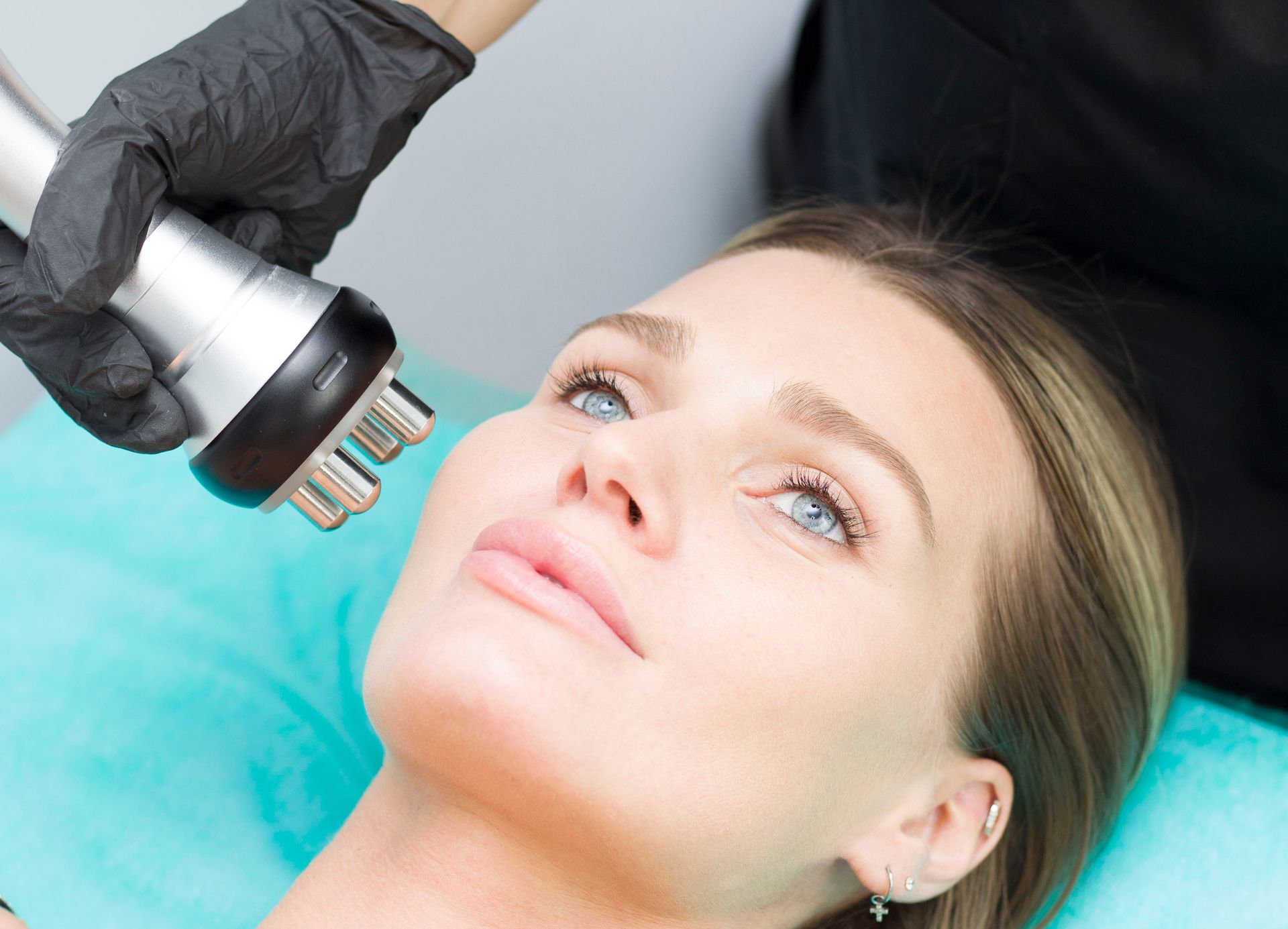 Woman receiving facial radiofrequency treatment.