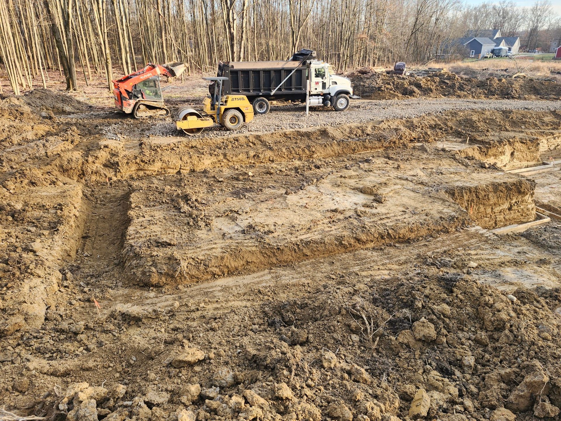 A dump truck is driving through a dirt field.