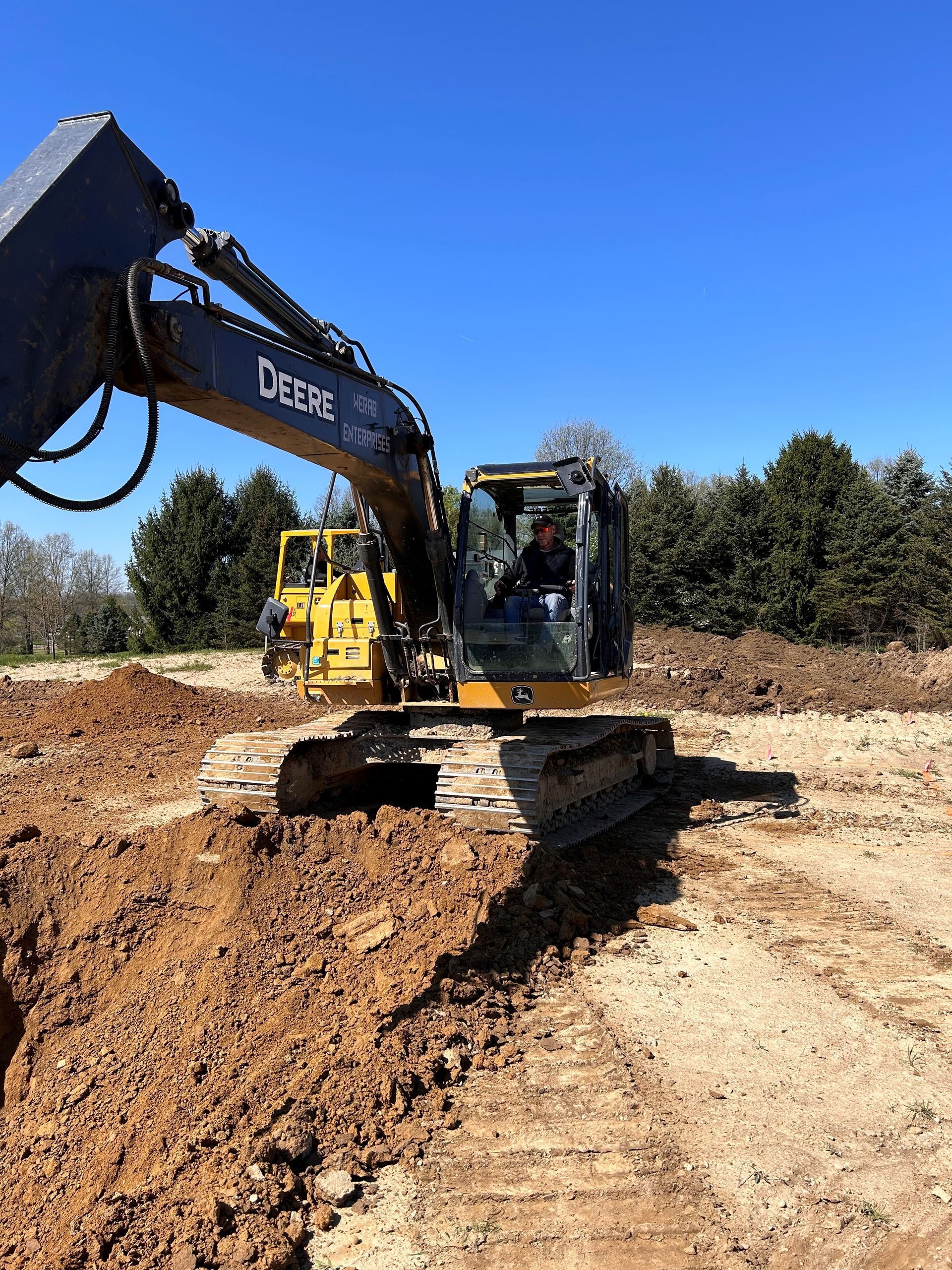 An excavator is moving dirt in a field.  | Atwater, OH | Werab Enterprises