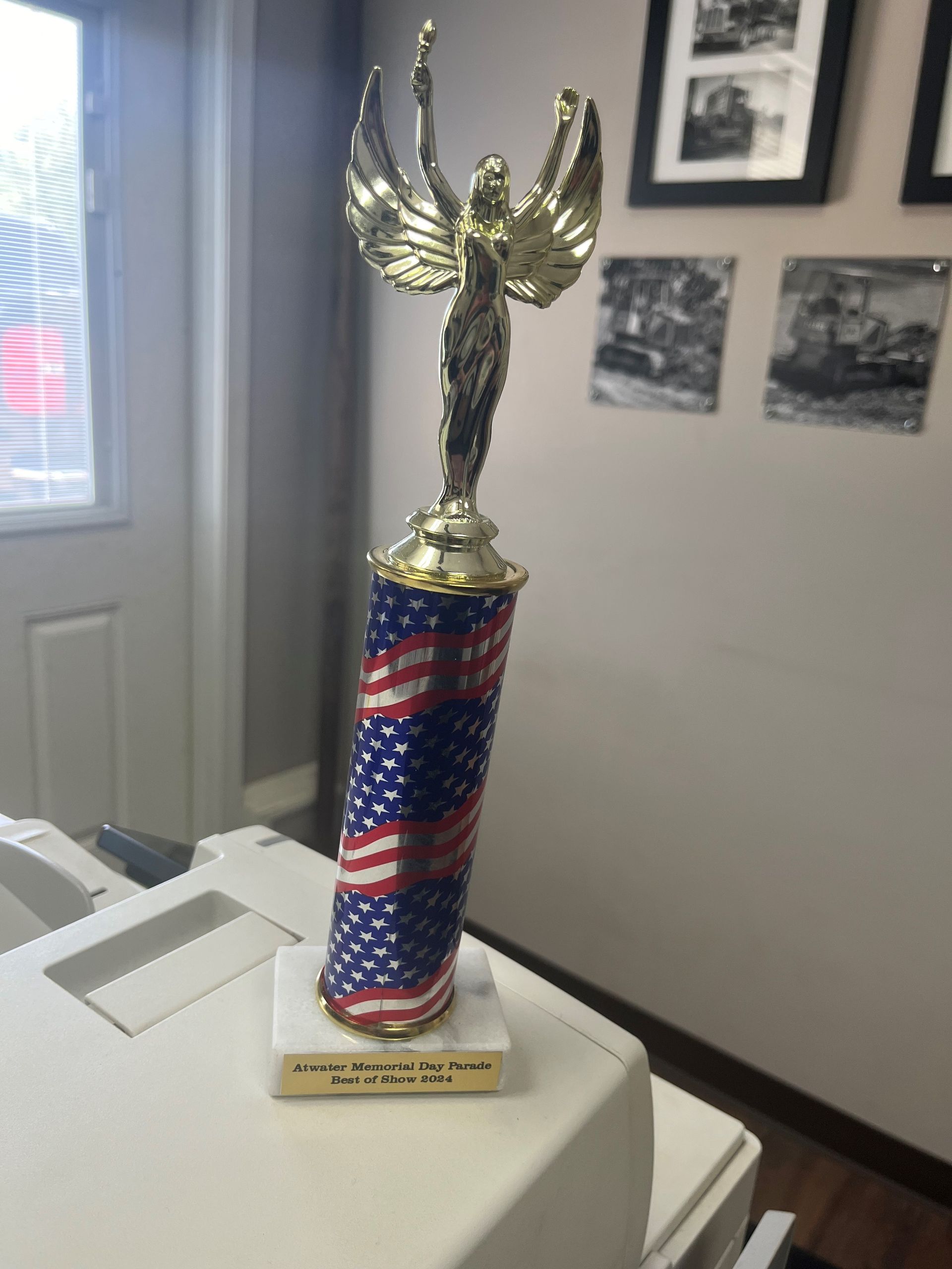 A red white and blue trophy with a statue on top