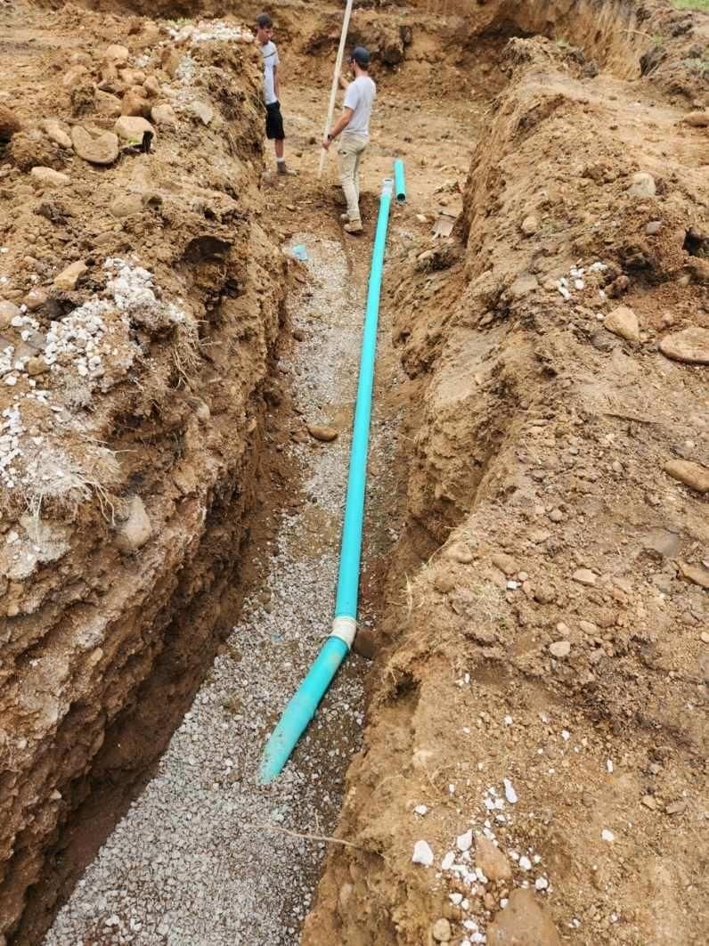 A man is standing next to a blue pipe in the dirt.  | Atwater, OH | Werab Enterprises