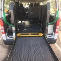 The back of a handicap van with the ramp open.