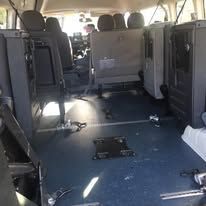 The inside of a van with a lot of seats and a blue floor.