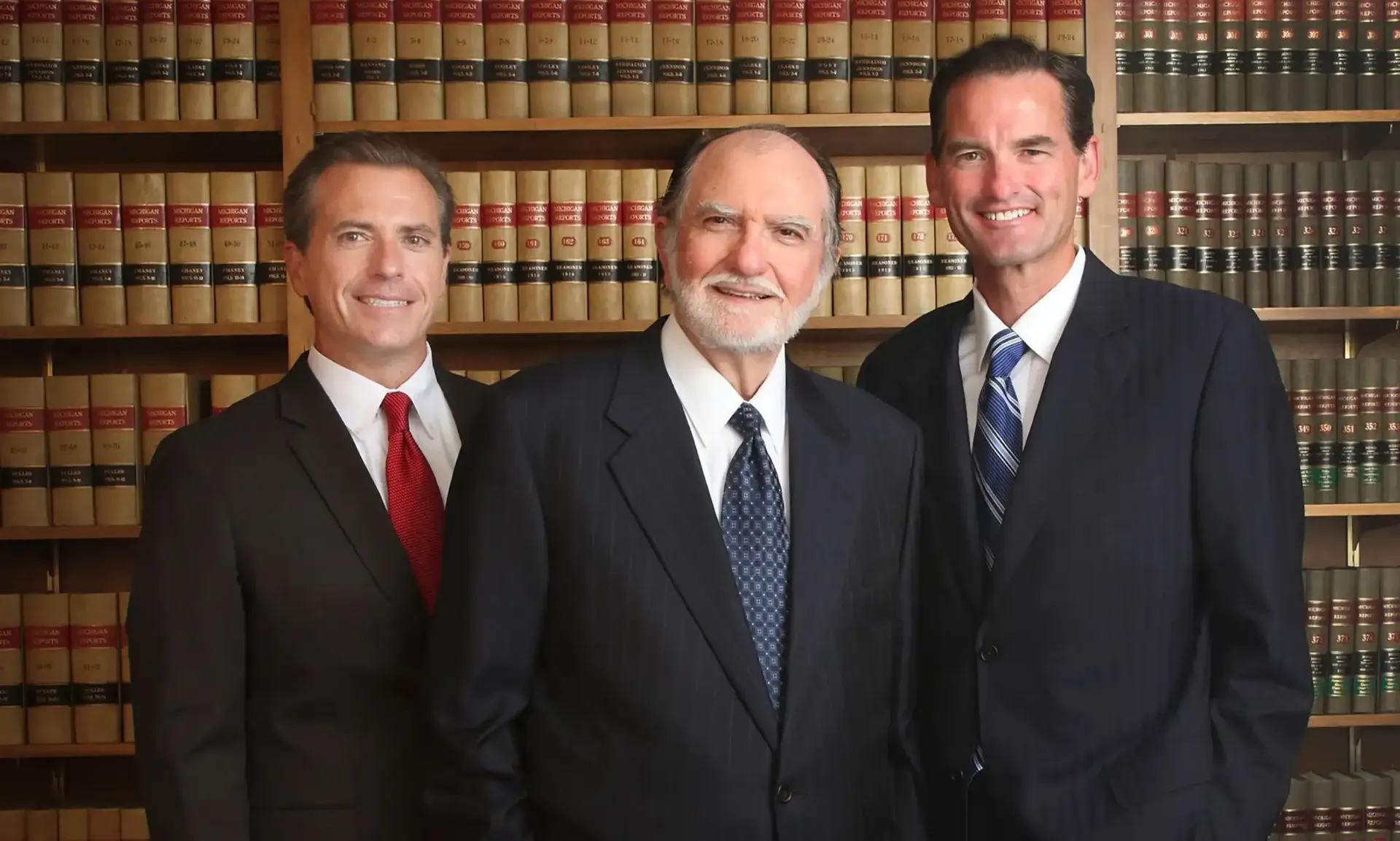 The three family law and personal injury attorneys of Gergely Law Offices are standing in a law library.