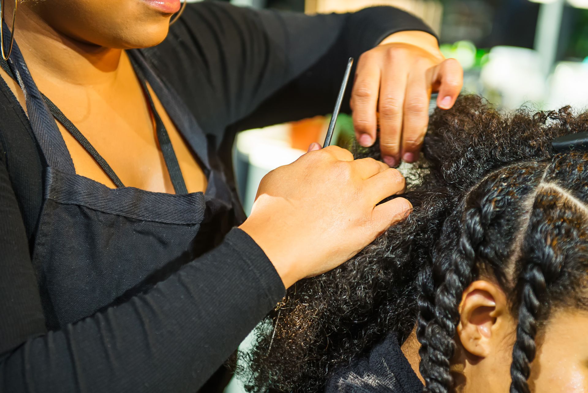 A woman is cutting a woman 's hair in a salon.
