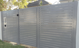 Gray horizontal slat fence with mailbox.