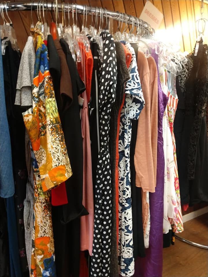 Rack of colorful dresses on hangers.