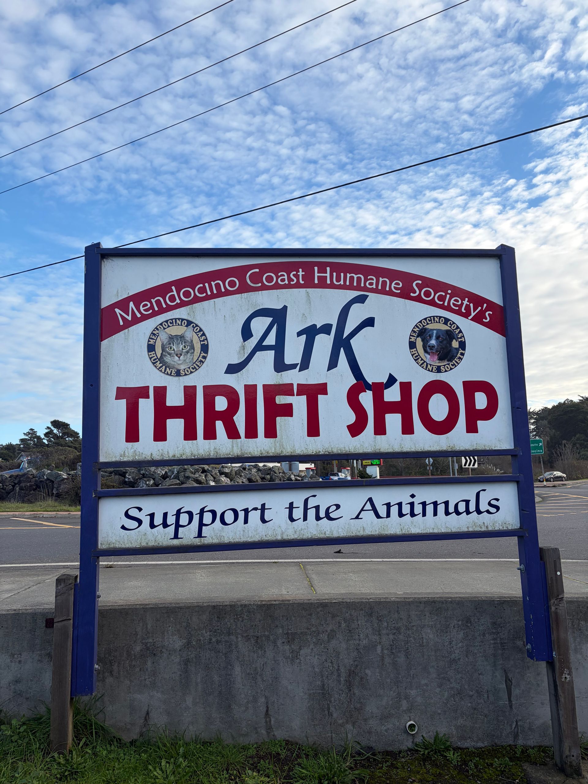 Sign for Ark Thrift Shop, Mendocino Coast Humane Society. Red, white, and blue, supports the animals, on side of a road.