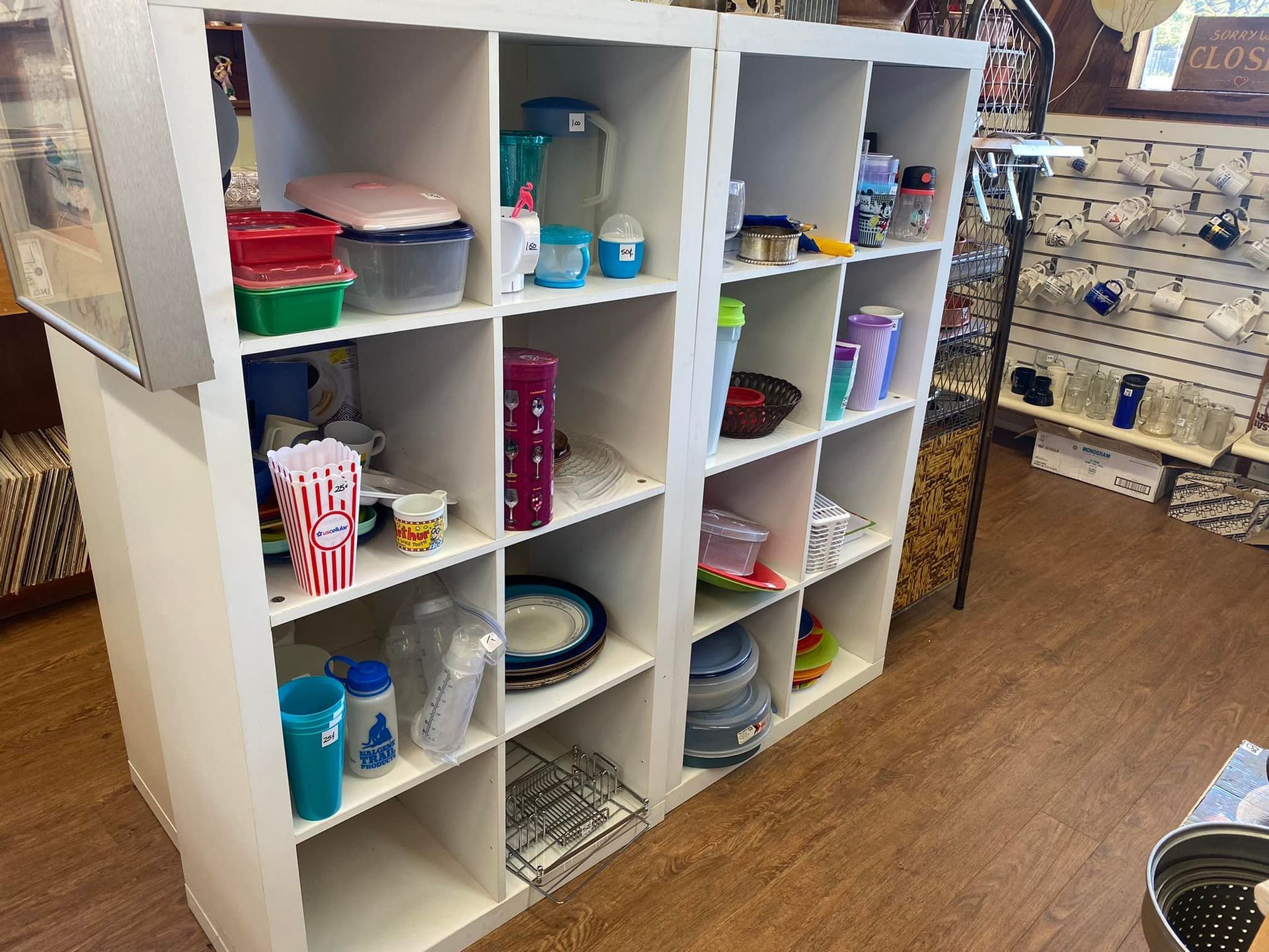 White cubed shelves displaying kitchenware in a store setting.