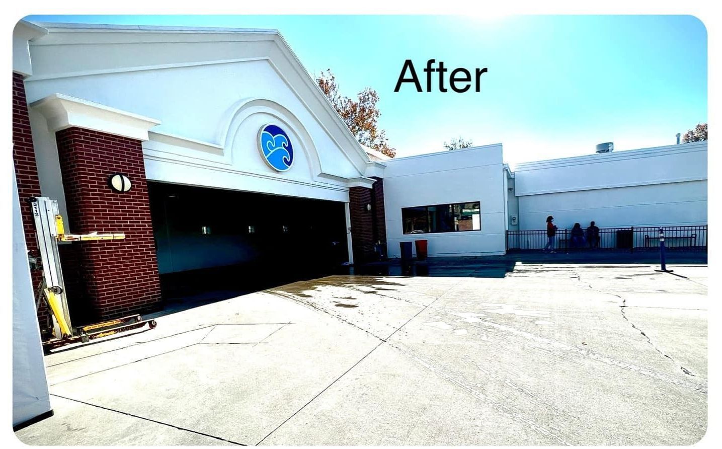 Car wash exterior with white and red brick building. A clear sky in the background.