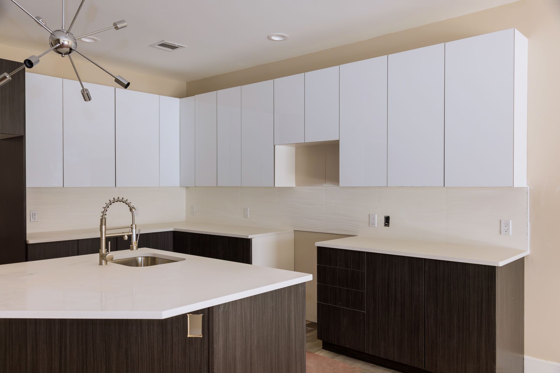 Modern kitchen with white and dark brown cabinets, a central island, and a stainless steel faucet.