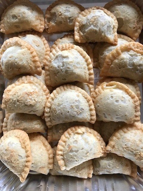 A bunch of fried pastries are stacked on top of each other on a plate.