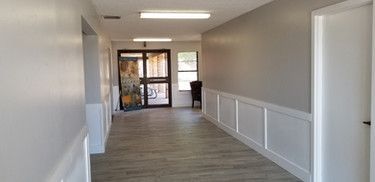 A long hallway with a door and a window in a building.