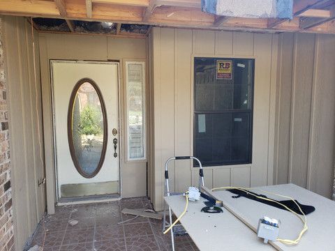 There is a table in front of a door and a window.