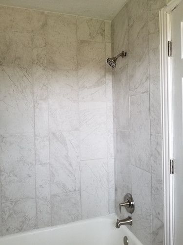 A bathroom with a bathtub and a shower head.