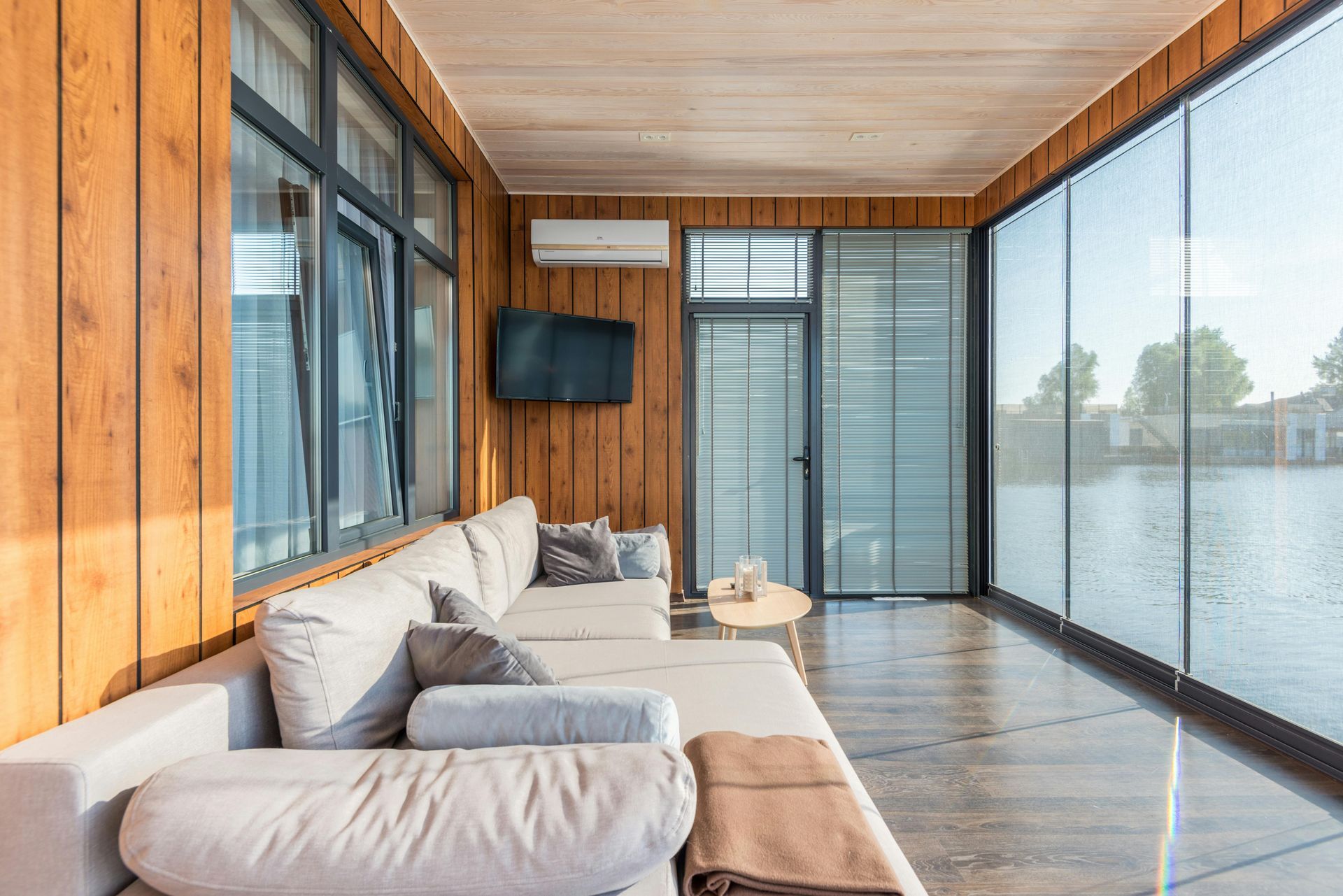 A living room with a couch and a television on the wall.