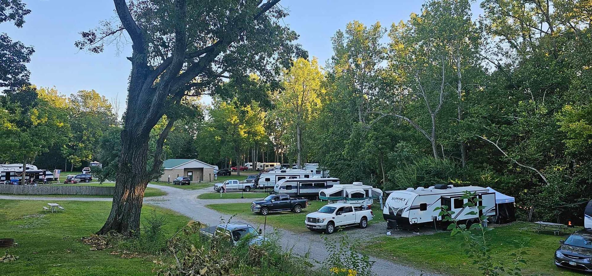 a white rv is parked in the middle of a campground
