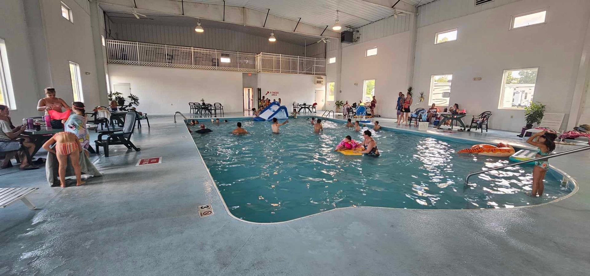 a large indoor swimming pool with people playing in it