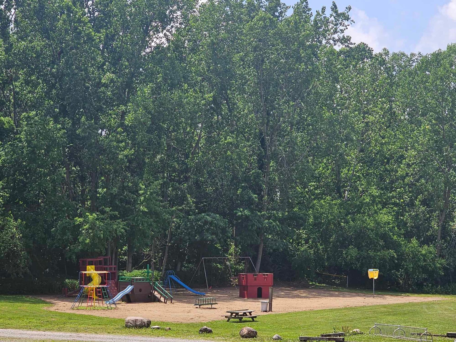 a playground with a yellow sign that says no dogs