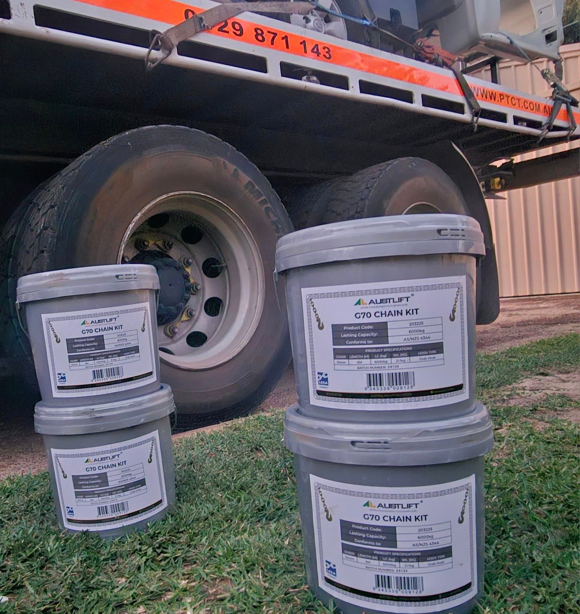 Several buckets are stacked on top of each other in front of a truck numbered 29 871 143