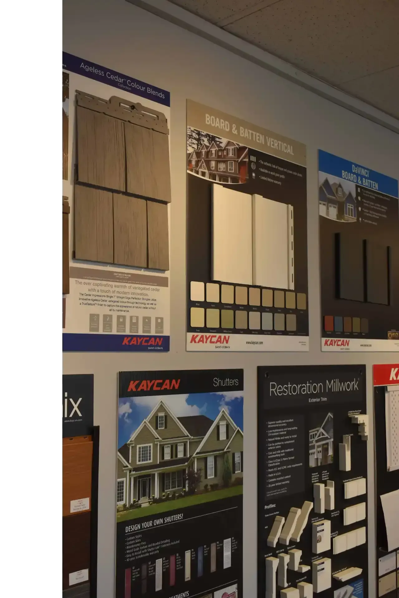 Wall displays with siding and trim samples. Kaycan product posters in a showroom.