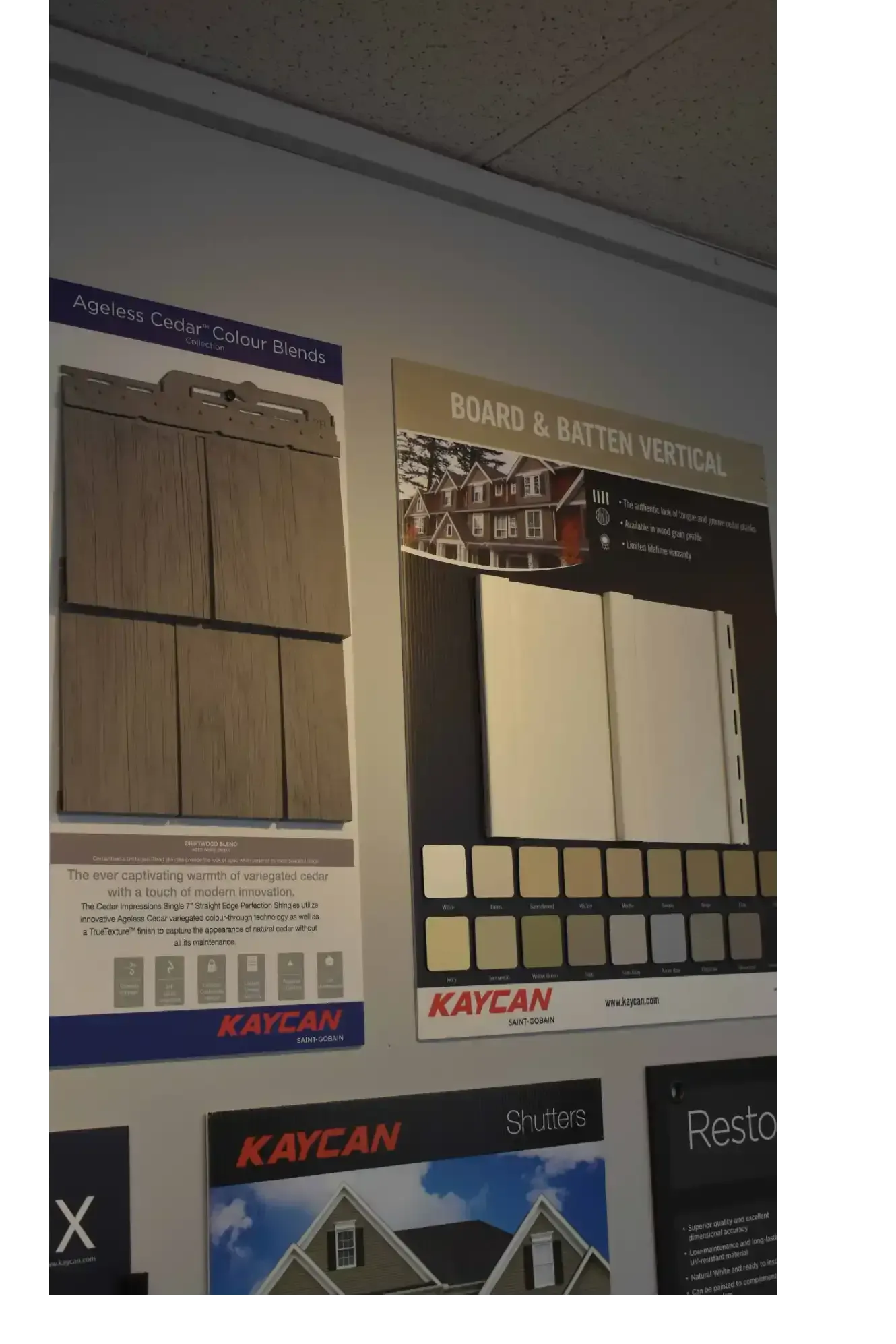 Displays of siding samples on a wall, showcasing different colors and styles, with the 