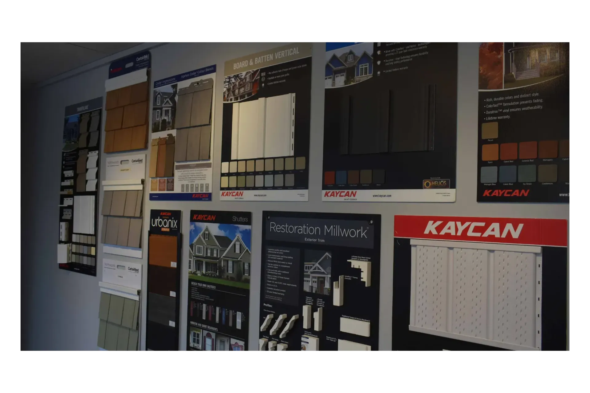 Wall display of building material samples and promotional posters.