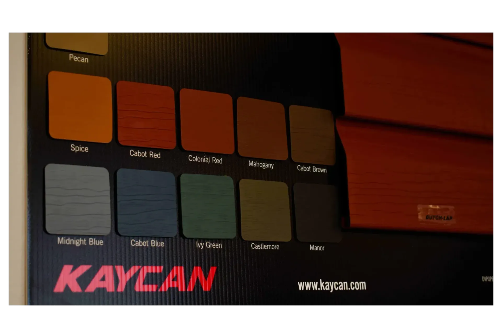 Color swatches on a Kaycan display board, featuring various shades of wood stains and painted finishes.