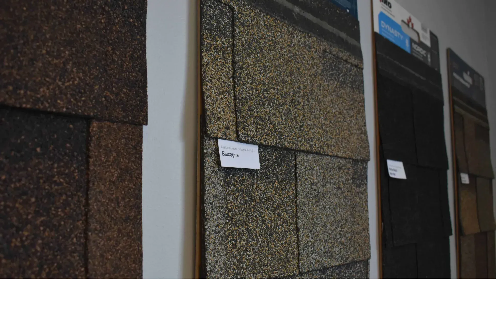 Samples of roofing shingles in various colors on display.
