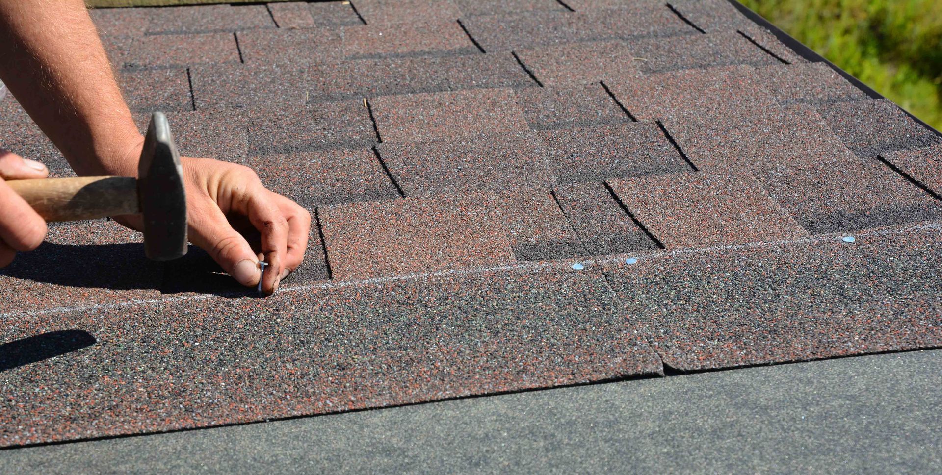 Hands installing asphalt roof shingles in a professional roofing project. Hands installing asphalt roof shingles in a professional roofing project.